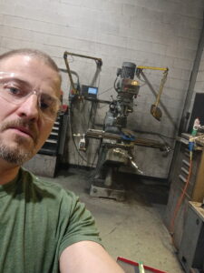 Charles Barfell in front of machinery at work.